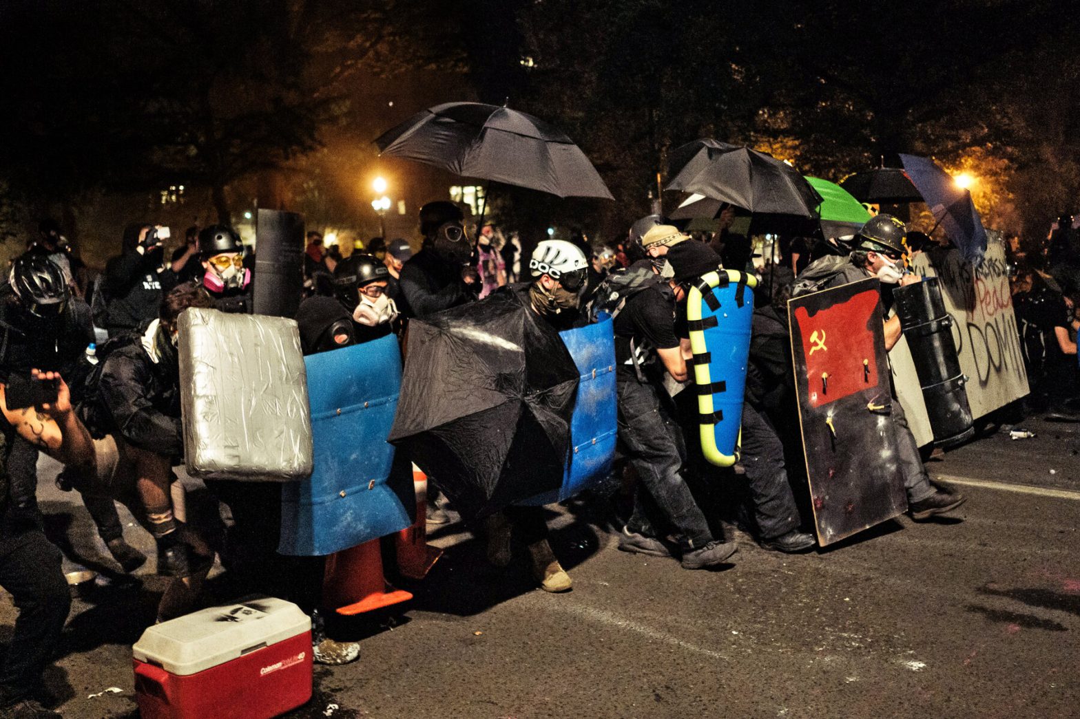 Wall of shields and umbrellas at a black bloc action in Portland